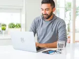 Man zit achter een laptop.